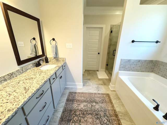bathroom featuring a bath, a stall shower, vanity, baseboards, and ornamental molding