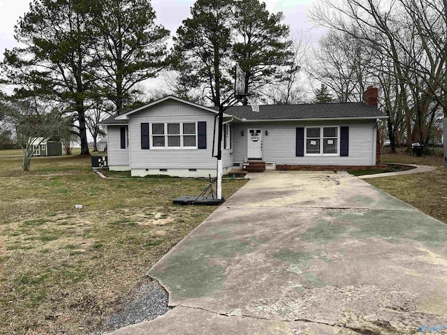 view of front of property with an outbuilding, a chimney, entry steps, crawl space, and a front yard