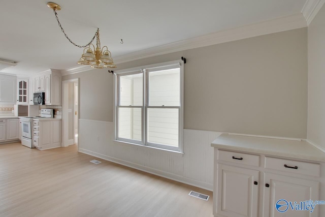 kitchen featuring hanging light fixtures, a chandelier, white cabinets, light wood-type flooring, and electric range