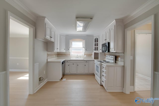 kitchen featuring light wood-type flooring, backsplash, sink, white cabinets, and electric range