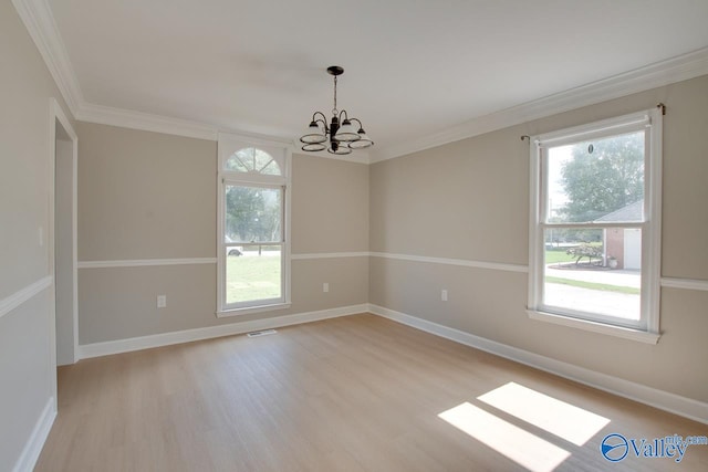 spare room with ornamental molding, light wood-type flooring, and a notable chandelier