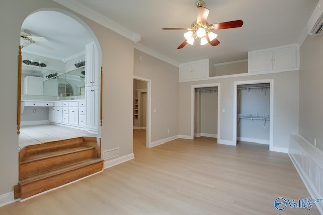 unfurnished bedroom with a wall mounted AC, light wood-type flooring, and ceiling fan