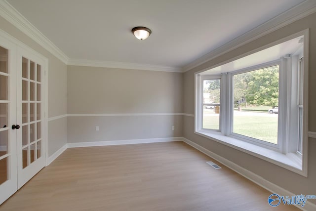 spare room with french doors, ornamental molding, and light hardwood / wood-style flooring