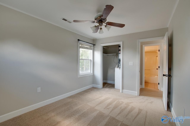 unfurnished bedroom with light colored carpet, ceiling fan, crown molding, and a closet