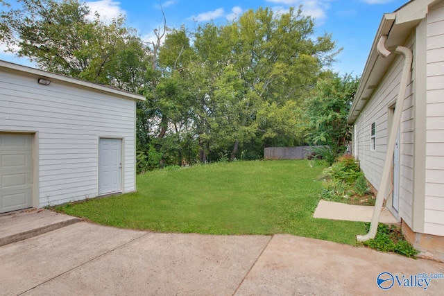 view of yard featuring a garage and a patio