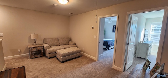 living area featuring carpet floors and ceiling fan