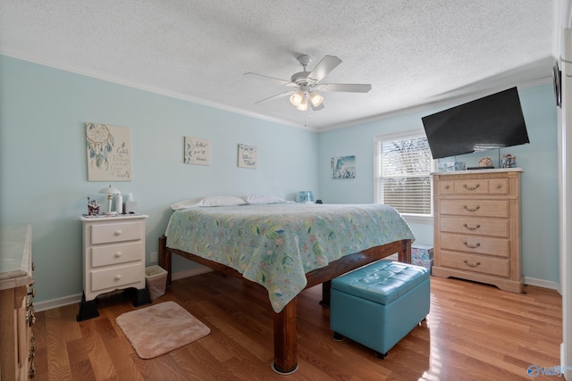 bedroom featuring ornamental molding, a textured ceiling, ceiling fan, and light wood-type flooring