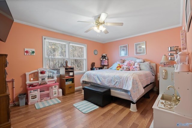 bedroom with ceiling fan, ornamental molding, and light hardwood / wood-style flooring