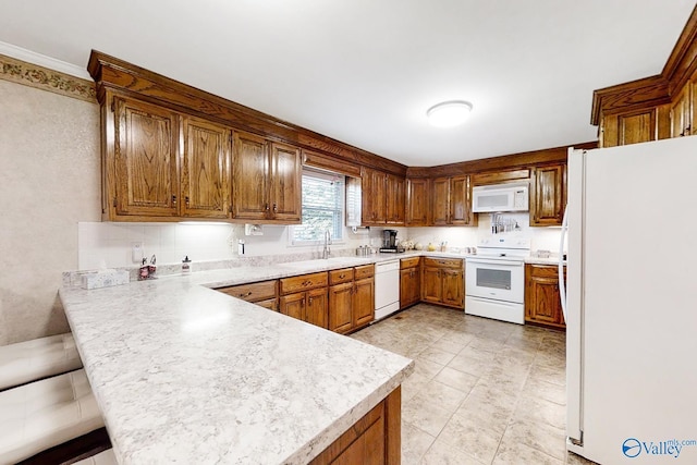 kitchen with white appliances, crown molding, kitchen peninsula, a breakfast bar, and sink