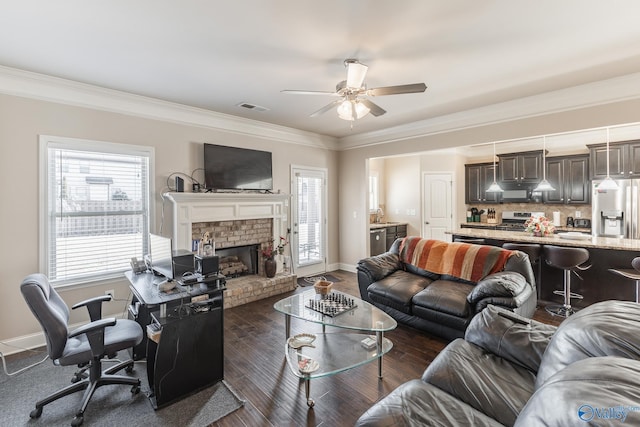 living room with ornamental molding, a brick fireplace, sink, and ceiling fan