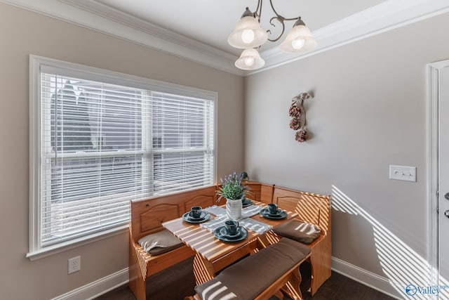 dining room with ornamental molding, a healthy amount of sunlight, and a notable chandelier