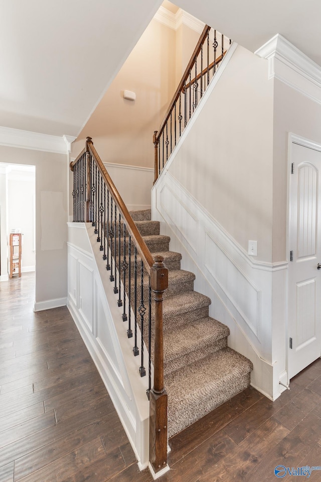 staircase with crown molding and hardwood / wood-style floors