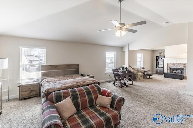 bedroom featuring ceiling fan, lofted ceiling, a stone fireplace, and light carpet