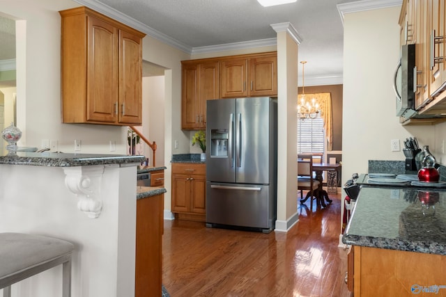 kitchen with stainless steel appliances, ornamental molding, dark hardwood / wood-style flooring, and an inviting chandelier