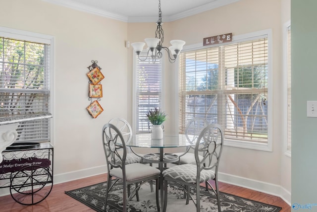 dining room with ornamental molding, a notable chandelier, and hardwood / wood-style floors