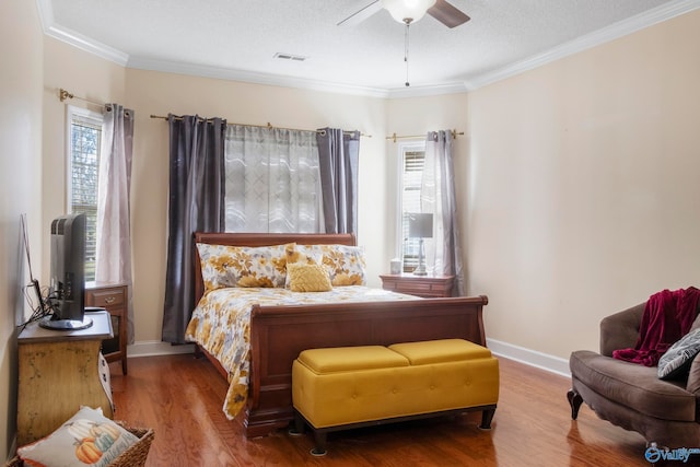 bedroom with a textured ceiling, crown molding, hardwood / wood-style flooring, and ceiling fan