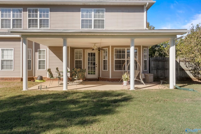 rear view of property with ceiling fan, a lawn, and a patio area