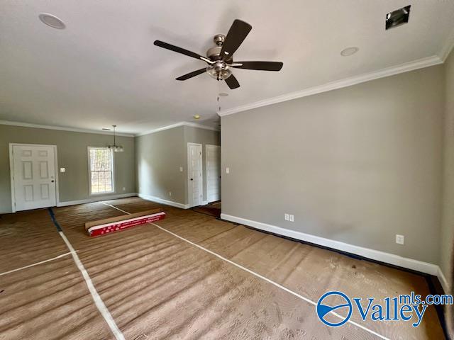 unfurnished living room with ceiling fan with notable chandelier, carpet floors, and ornamental molding