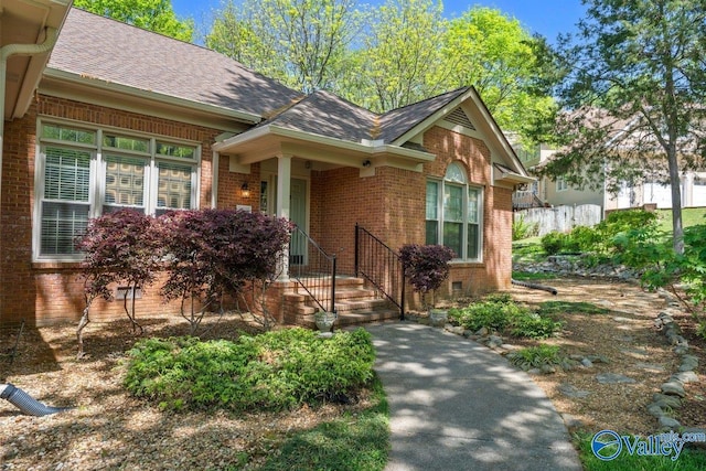 view of front of home with brick siding and a shingled roof