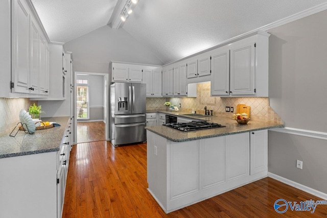kitchen featuring a peninsula, backsplash, rail lighting, and stainless steel fridge with ice dispenser