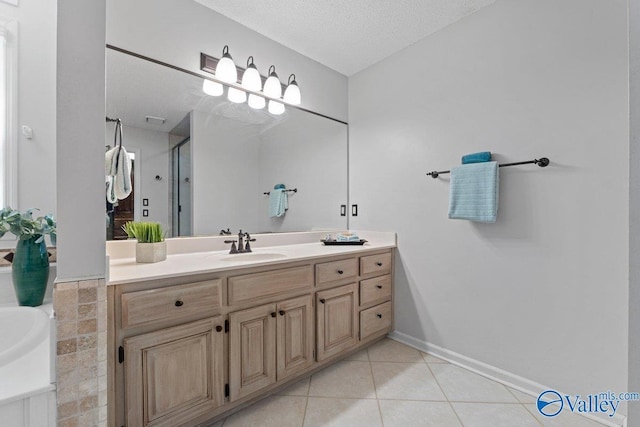 full bathroom featuring tile patterned floors, a textured ceiling, a stall shower, baseboards, and vanity