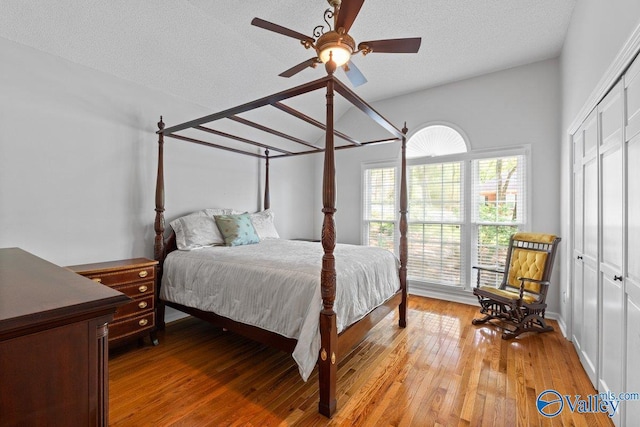 bedroom with a ceiling fan, a closet, a textured ceiling, and light wood-type flooring