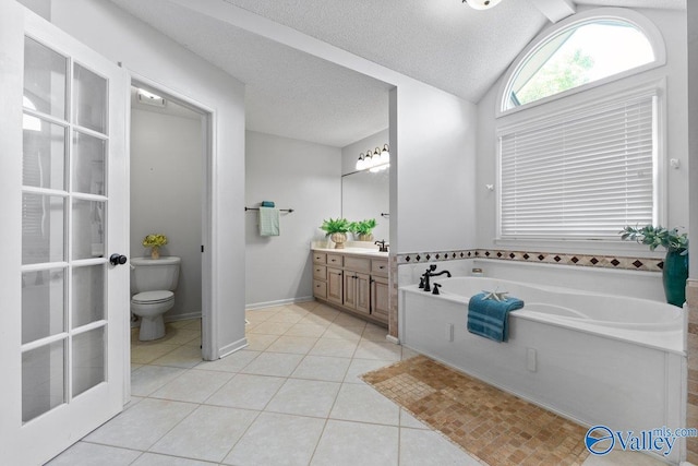 full bath with tile patterned floors, toilet, vaulted ceiling, a garden tub, and vanity