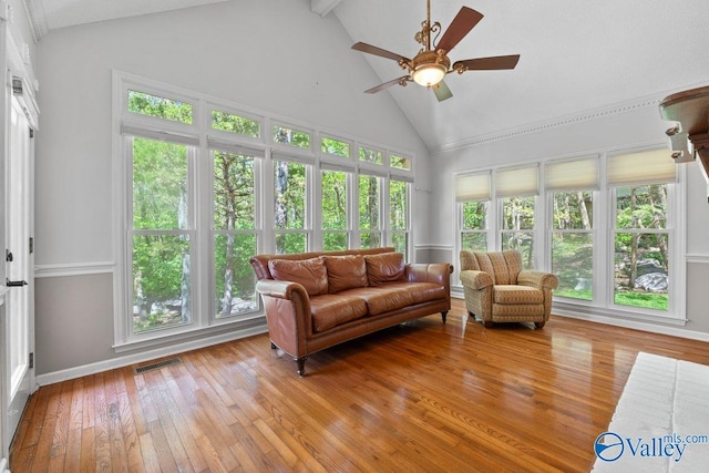sunroom featuring plenty of natural light, visible vents, high vaulted ceiling, and wood-type flooring