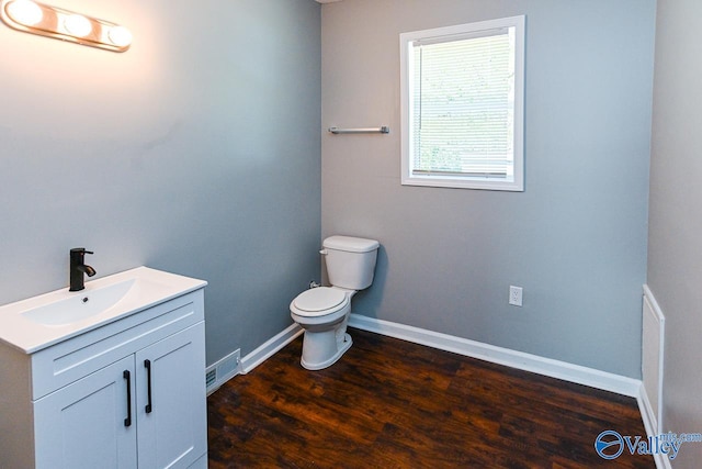 bathroom featuring toilet, hardwood / wood-style flooring, and vanity