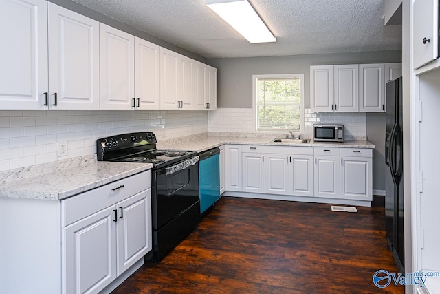 kitchen featuring dark wood-type flooring, backsplash, sink, black appliances, and white cabinets