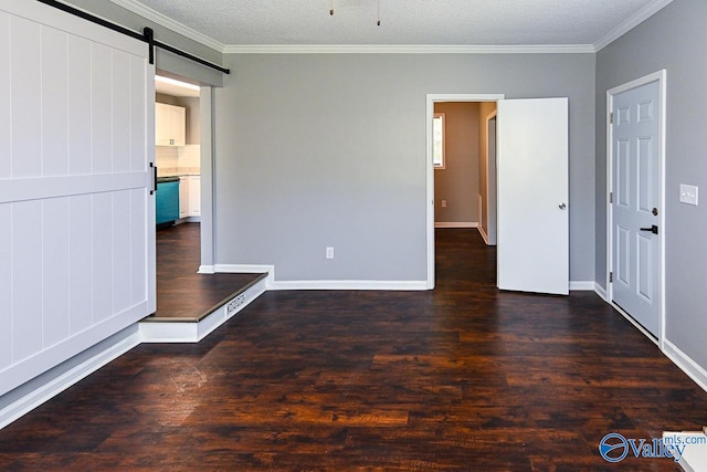 unfurnished bedroom with ornamental molding, dark hardwood / wood-style floors, a barn door, and a textured ceiling