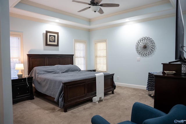 bedroom with a tray ceiling, crown molding, light colored carpet, and ceiling fan