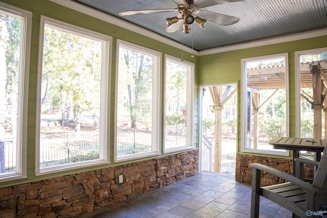 sunroom / solarium featuring a healthy amount of sunlight and ceiling fan