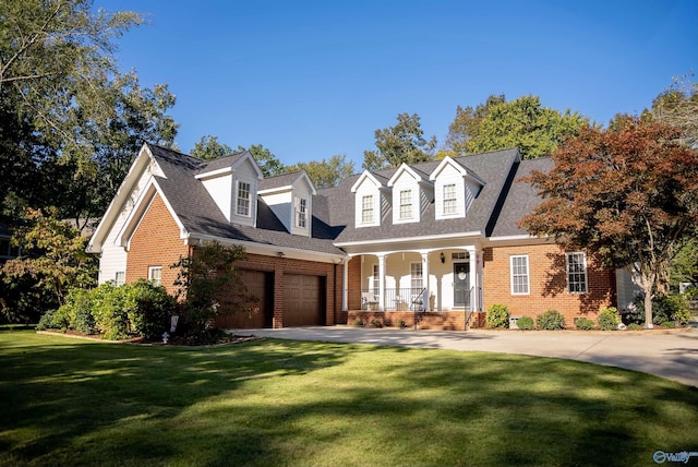 new england style home featuring a garage, a front lawn, and covered porch