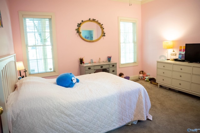 bedroom featuring multiple windows, crown molding, and carpet