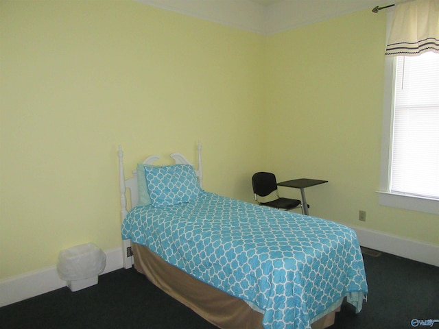 bedroom with dark colored carpet and multiple windows