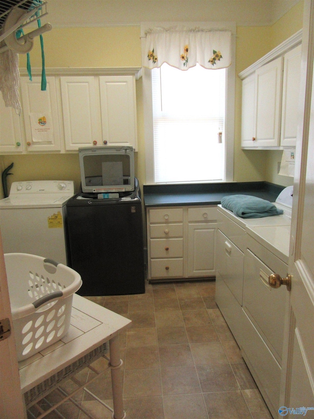 laundry area featuring cabinets, washing machine and dryer, and tile patterned flooring