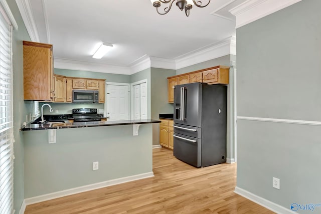 133 Raccoon Trce, Huntsville, AL 35806 - kitchen featuring stainless steel appliances, a peninsula, dark countertops, light wood finished floors, and ornamental molding