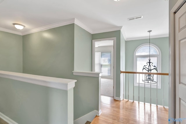 133 Raccoon Trce, Huntsville, AL 35806 - hallway featuring a chandelier, light wood-style floors, ornamental molding, and an upstairs landing