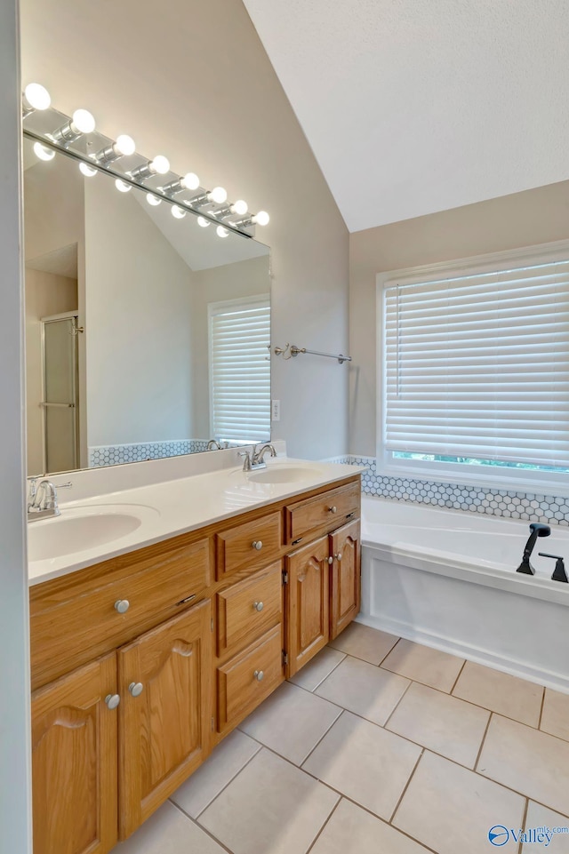 133 Raccoon Trce, Huntsville, AL 35806 - full bathroom featuring vaulted ceiling, tile patterned floors, double vanity, a garden tub, and a stall shower