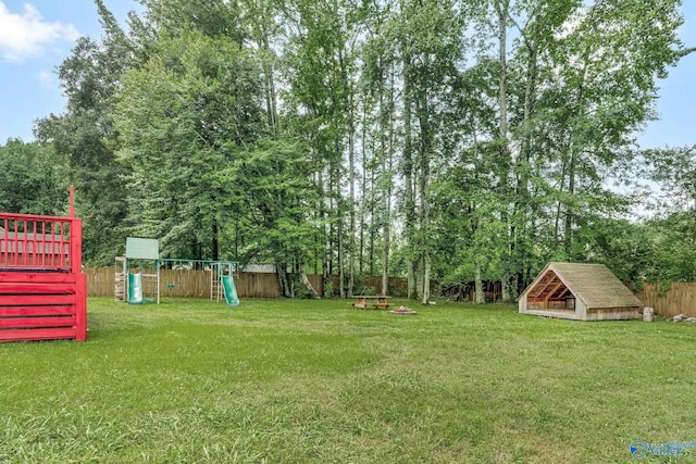 133 Raccoon Trce, Huntsville, AL 35806 - fenced backyard featuring a playground and view of wooded area