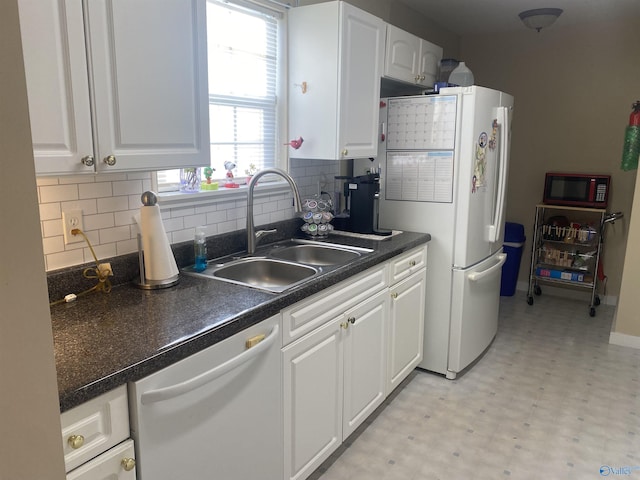 kitchen featuring white cabinetry, sink, tasteful backsplash, and white appliances