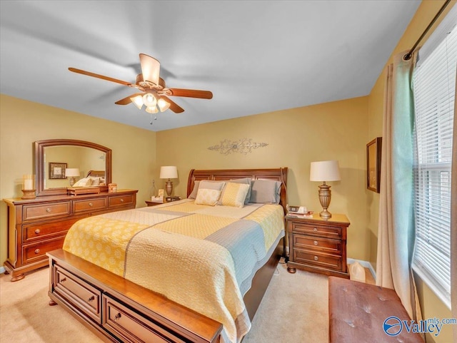 bedroom featuring light colored carpet, multiple windows, and a ceiling fan