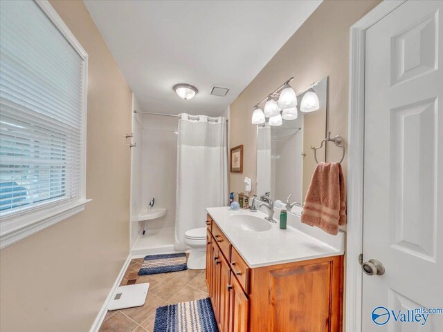 bathroom with tile patterned floors, a shower with curtain, toilet, vanity, and baseboards