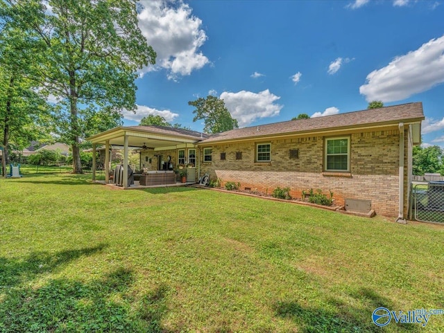 rear view of house with ceiling fan, outdoor lounge area, brick siding, and a patio area