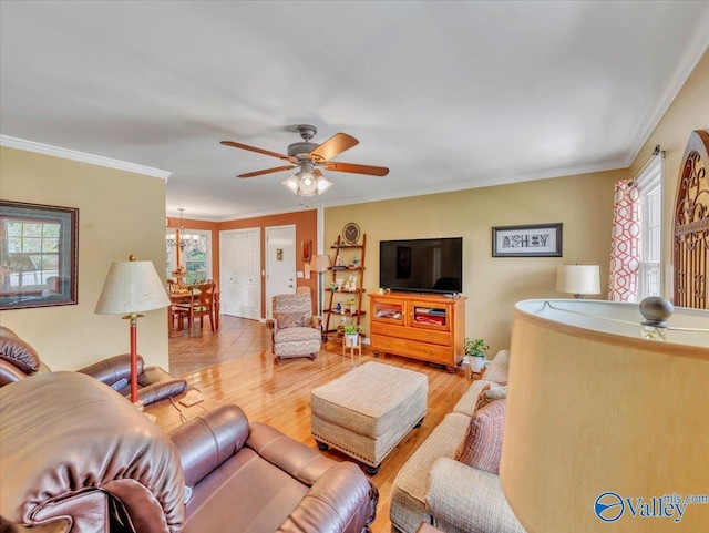 living area with healthy amount of natural light, ceiling fan, crown molding, and wood finished floors