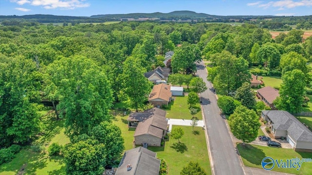 view of property location with a heavily wooded area and nearby suburban area