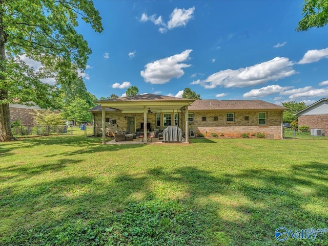 rear view of property with a patio, an outdoor living space, and stone siding