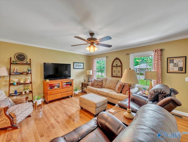 living room featuring ceiling fan, baseboards, light wood-style flooring, and ornamental molding