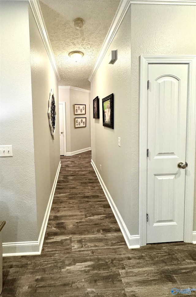 corridor featuring dark wood-type flooring, ornamental molding, and a textured ceiling